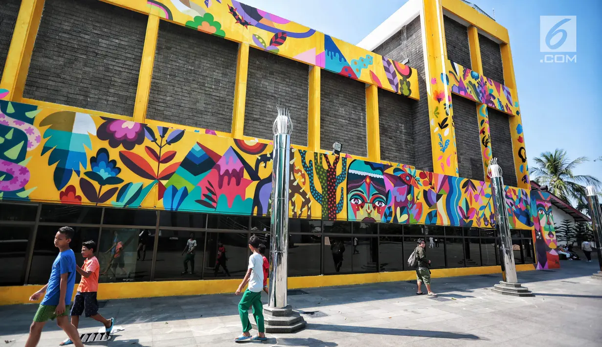 Sejumlah warga berjalan di dekat karya seni Mural di Taman Ismail Marzuki (TIM), Cikini, Jakarta, Selasa (11/9). Mural tersebut dibuat oleh seniman asal Kolombia Diana Ordonez. (Liputan6.com/Faizal Fanani)