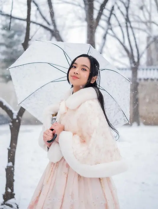 Sambil membawa payung, Lyodra pun mengenakan makeup dengan tone warna seperti eyeshadow orange dan lipstik nude serasi dengan hanboknya. [@lyodraofficial]