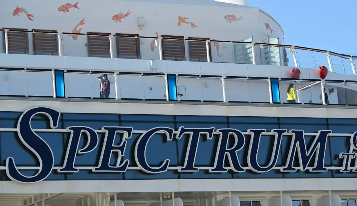 Penumpang dan awak terlihat pada kapal pesiar Spectrum of the Seas di Hong Kong, Rabu (5/1/2022). Spectrum of the Seas diperintahkan kembali ke kota untuk pengujian virus corona COVID-19 setelah sembilan orang ditemukan memiliki kontak dekat dengan varian Omicron baru-baru ini. (PETER PARKS/AFP)