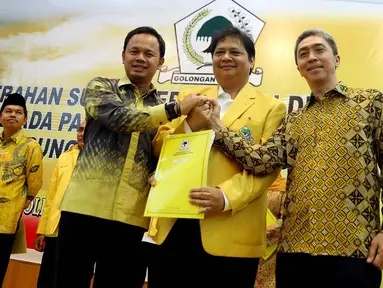 Ketum DPP Partai Golkar Airlangga Hartarto (tengah) memberikan surat rekomendasi bakal calon Walikota Bogor Bima Arya Sugiarto dan bakal calon wakil Walikota Bogor Dedie A Rachim di Kantor DPP Partai Golkar, Jakarta, Jumat (5/1). (Liputan6.com/JohanTallo)