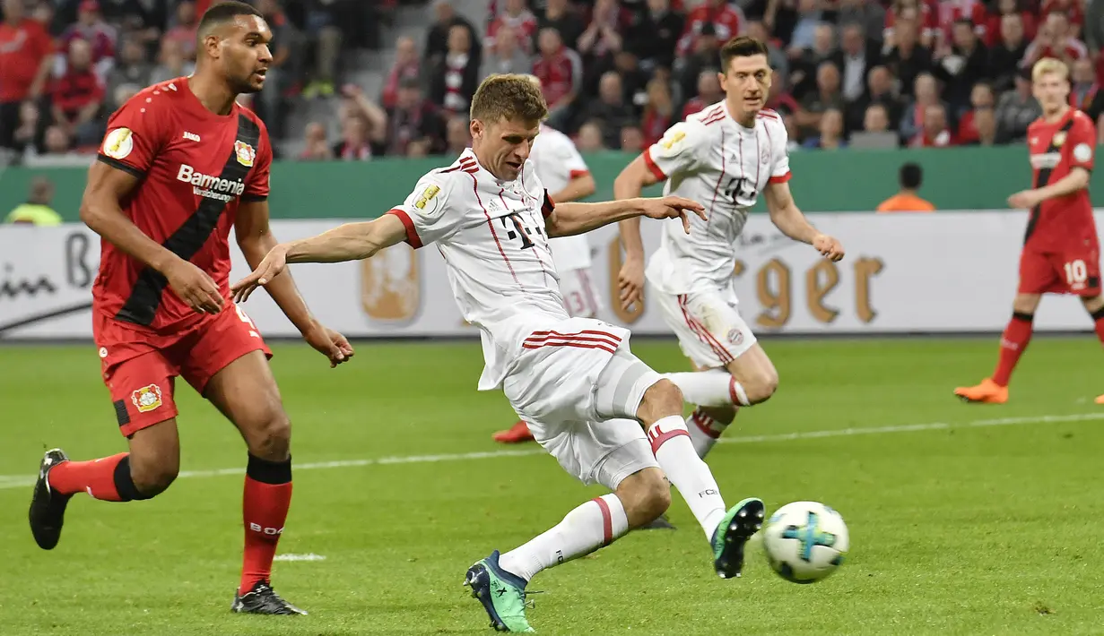 Penyerang Bayern Munchen, Thomas Mueller, melepaskan tendangan ke gawang Bayer Leverkusen pada laga DFB Pokal di Stadion BayArena, Selasa (17/4/2018). Bayern Munchen menang 6-2 atas Bayer Leverkusen. (AP/Martin Meissner)
