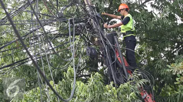 Petugas PLN mengecek instalasi kabel di tiang listrik milik PLN, Jakarta (26/2). Mulai 28 Februari 2016, PLN berencana membongkar perangkat atau jaringan telematika yang memanfaatkan tiang listrik di Jakarta tanpa izin. (Liputan6.com/Immanuel Antonius)