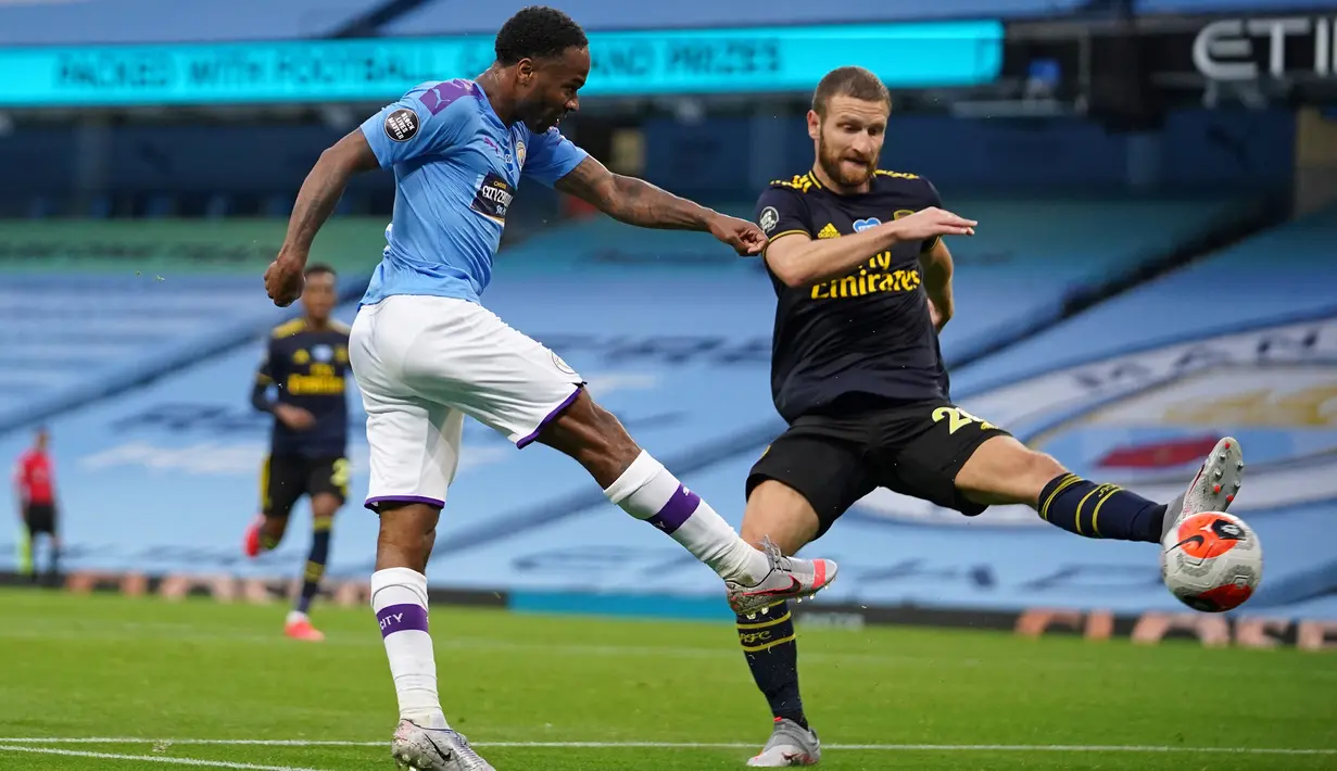Pemain Manchester City Raheem Sterling (kiri) mencetak gol ke gawang Arsenal pada laga Premier League di Etihad Stadium, Manchester, Inggris, Rabu (17/6/2020). Manchester City menang dengan skor 3-0. (Dave Thompson/POOL/AFP)