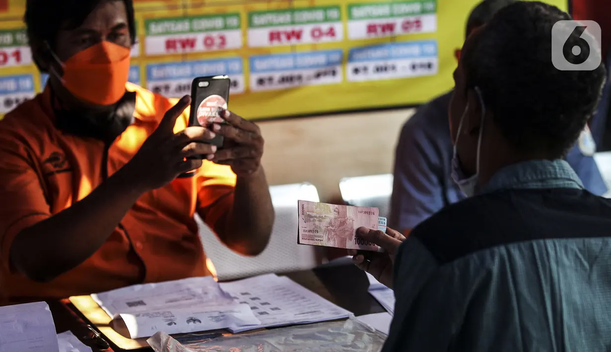 Petugas memotret warga penerima bantuan sosial (bansos) di kawasan Kedoya Selatan, Jakarta Barat, Rabu (28/7/2021). Selain bansos dari APBD DKI Jakarta, sekitar 738 ribu orang lainnya mendapatkan bantuan yang disalurkan oleh pemerintah pusat melalui Kementerian Sosial. (Liputan6.com/Johan Tallo)