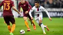 Gelandang Lyon, Corentin Tolisso (kanan) berusaha membawa bola melewati pemain AS Roma pada leg pertama babak 16 besar Liga Europa di Stade de Lyon, Prancis, (9/3). Lyon berhasil mengalahkan AS Roma dengan skor 4-2. (AFP Photo / Romain Lafabregue)