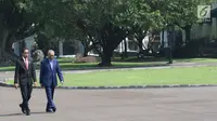 Presiden Joko Widodo (Jokowi) berjalan bersama PM Malaysia, Mahathir Mohamad usai menaman pohon di halaman belakang Istana Bogor, Jumat (29/6). Sebelum kegiatan menanam pohon, PM Malaysia disambut dengan upacara kenegaraan. (Liputan6.com/Angga Yuniar)