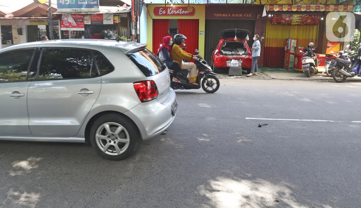 Cynthia (28) mahasiswi perguruan tinggi swasta menunggu pembeli  di Jalan Santosa, Depok, Jawa Barat, Kamis (21/5/2020). Cynthia menggunakan mobil pribadinya sebagai lapak berjualan berbagai macam sayuran dengan harga serba Rp 5.000. (Liputan6.com/Herman Zakharia)