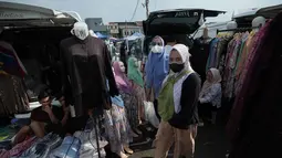Terletak tidak jauh dari Stasiun KRL Tanah Abang, pasar ini menawarkan beragam busana muslim dengan harga yang relatif terjangkau, baik secara eceran maupun grosiran. Tampak dalam foto, warga berjalan melewati toko-toko pakaian saat mereka bersiap berbelanja untuk keperluan perayaan hari raya Idul Fitri di salah satu pasar musiman di Jakarta, Senin 9 Maret 2026. (AP Photo/Achmad Ibrahim)