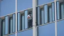 Urban climber atau pemanjat gedung, Alain Robert membuat skala saat memanjat Menara Lotte World di Seoul, Korea Selatan (6/6). Alain Robert gagal menaklukan gedung setinggi 123 lantai karena dicegat dan diamankan petugas setempat. (AFP/Ed Jones)