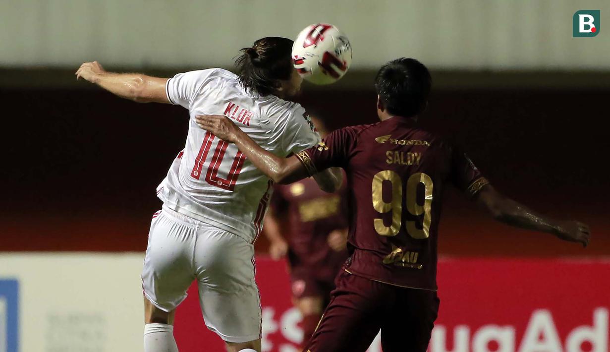 Gelandang Persija Jakarta, Marc Anthony Klok (kiri) berebut bola di udara dengan gelandang PSM Makassar, Saldi dalam laga leg pertama semifinal Piala Menpora 2021 di Stadion Maguwoharjo, Sleman, Kamis (15/4/2021). Kedua tim bermain imbang 0-0. (Bola.com/Ikhwan Yanuar)