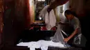 Pekerja mencuci kain yang menjadi bahan dasar pembuatan batik di Kampung batik, Jetis, Sidoarjo, Senin (31/03/2015). Produksi batik Kota Sidoarjo ini sejak tahun 1960-an hingga saat ini masih tetap bertahan.  (Liputan6.com/Andrian M Tunay)
