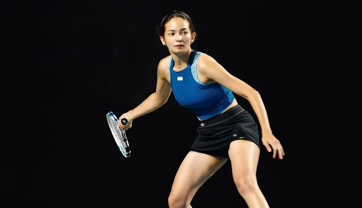 Potret sporty Enzy Stroia dengan outfit tenis. Atasan tanpa lengan cropped tank top biru navy dipadu dengan pants hitam, dan sepatu putih. Foto: Instagram.
