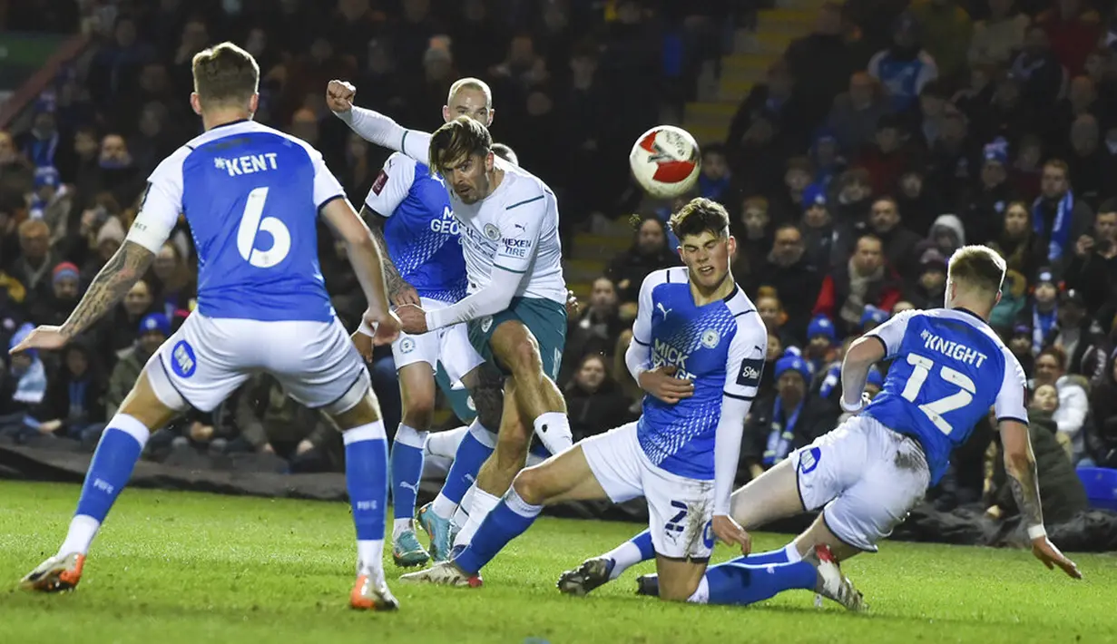 Pemain Manchester City Jack Grealish (tengah) menendang bola saat melawan Peterborough United pada pertandingan sepak bola putaran kelima Piala FA di Stadion Weston Homes, Peterborough, Inggris, 1 Maret 2022. Manchester City menang 2-0. (AP Photo/Rui Vieira)