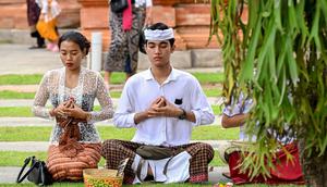 Saat Hari Raya Galungan umat Hindu akan memasang Penjor di tepi jalan setiap rumahnya yang merupakan aturan kehadapan Bhatara Mahadewa. (SONNY TUMBELAKA/AFP)
