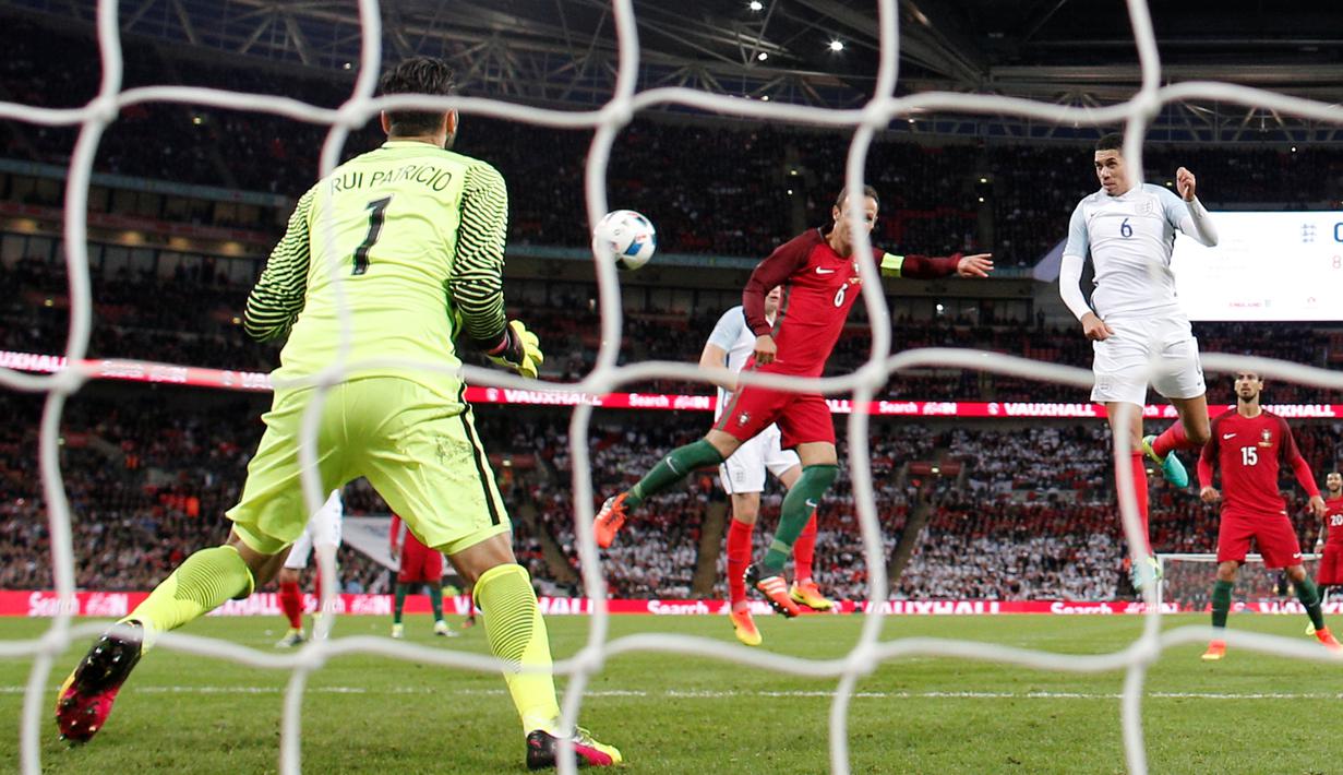 Pemain Inggris, Chris Smalling, saat mencetak gol ke gawang Portugal dalam laga persahabatan di Stadion Wembley, London, Kamis (2/6/2016). (AFP/Adrian Dennis)