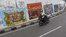 Kendaraan melintasi mural bertema Pemilu 2019 di kawasan Dukuh Atas, Jakarta, Senin (1/4). Mural-mural tersebut dibuat dalam rangka menyukseskan Pemilu yang akan berlangsung pada 17 April 2019 mendatang. (Liputan6.com/Immanuel Antonius)