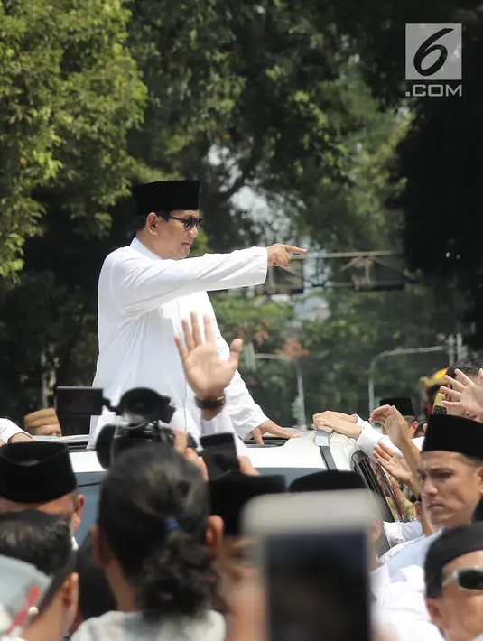 Bakal Calon Presiden, Prabowo Subianto berdiri di atas mobilnya dalam perjalanan menuju Gedung KPU RI, Jakarta, Jumat (10/8). Ketua Umum Gerindra Prabowo Subianto berangkat ke KPU untuk mendaftarkan diri sebagai capres. (Liputan6.com/Herman Zakharia)