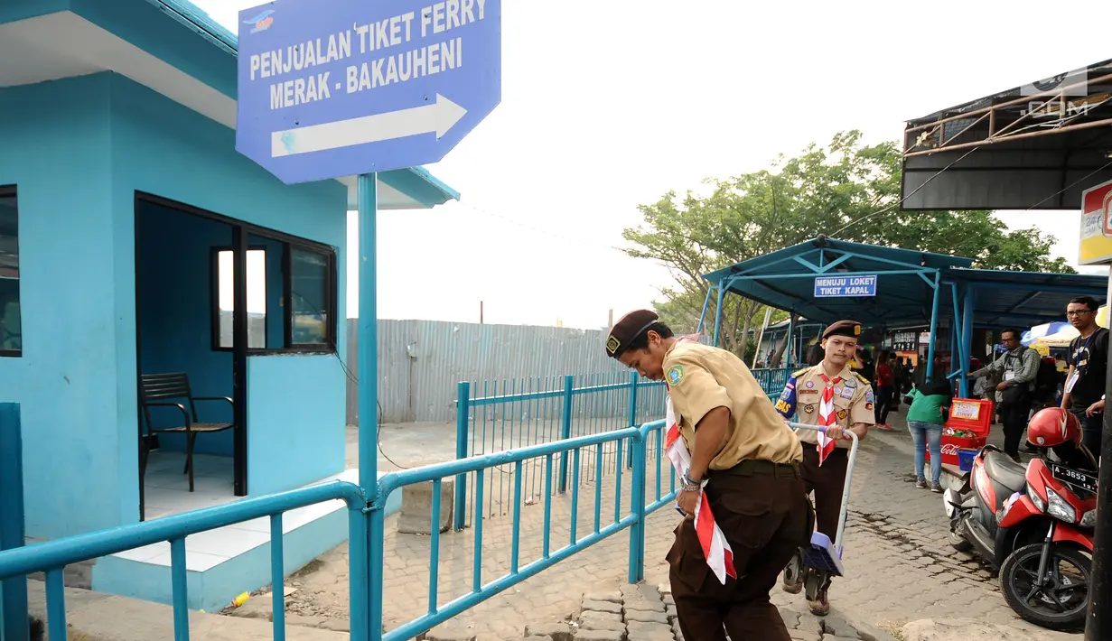Anggota Pramuka mengangkat troli dorong di kawasan Pelabuhan Merak, Banten, Kamis (22/6). Di Pelabuhan Merak, sejumlah anggota Pramuka diterjunkan untuk membantu pemudik membawa barang bawaan. (Liputan6.com/Helmi Fithriansyah)