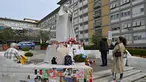 Orang-orang berdiri di depan patung Yohanes Paulus II di luar Rumah Sakit Universitas Gemelli tempat Paus Fransiskus dirawat karena pneumonia, di Roma pada 8 Maret 2025. (ANDREAS SOLARO/AFP atau pemberi lisensi/AFP)