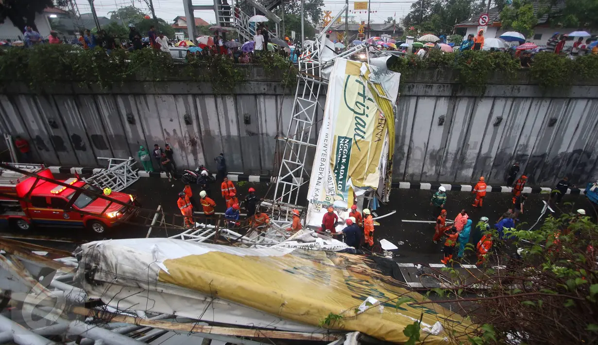 Petugas berusaha memotong bagian JPO yang roboh di Jalan Raya Pasar Minggu, Jakarta Selatan, Sabtu (24/09). Identitas korban meninggal masih belum teridentifikasi. (Liputan6.com/Immanuel Antonius)