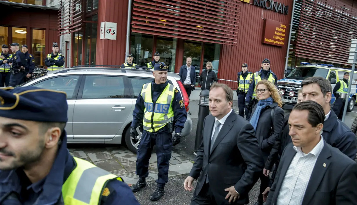 PM Swedia Stefan Lofven (tengah) mengunjungi sekolah Kronan di Trollhattan , pacsa terjadinya penyerangan oleh pria bertopeng dan bersenjatakan pedang, Kamis (22/10). Akibat kejadian itu, seorang guru dan murid tewas. (REUTERS/Adam Ihse/TT News Agency)
