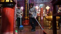 Personel Polresta Bandar Lampung gotong royong membersihkan vihara menyambut Waisak 2025. Foto : (Istimewa).