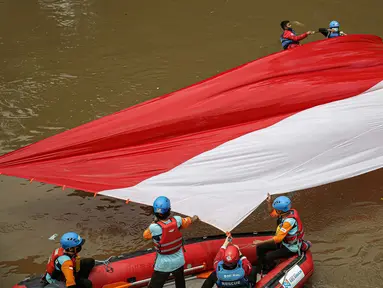 Sejumlah relawan membentangkan bendera Merah Putih di aliran kali
Ciliwung di kawasan Sudirman, Jakarta, Minggu (22/8/2021). Pembentangan atau pengibaran bendera Merah Putih tersebut dilaksanakan untuk memperingati HUT ke-76 RI. (Liputan6.com/Faizal Fanani)