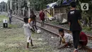 Anak-anak bermain di tengah perlintasan kereta api kawasan Ancol, Jakarta Utara, Kamis (19/5/2022). Kelompok umur kasus diduga hepatitis akut terbanyak adalah di bawah 5 tahun ada tujuh kasus, 6 sampai 10 tahun ada dua kasus, dan 11-16 tahun ada lima kasus. (Liputan6.com/Johan Tallo)