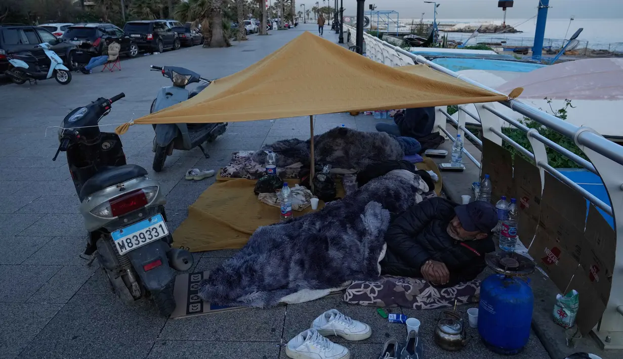 Para pengungsi yang melarikan diri dari serangan udara Israel di Dahiyeh, pinggiran selatan Beirut, beristirahat di tepi pantai Beirut, Lebanon, Jumat 6 Maret 2026. Ratusan orang di Beirut, Lebanon, terpaksa tidur di tepi pantai dan trotoar dengan kondisi seadanya. (AP Photo/Hussein Malla)