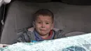 Seorang bocah menangis saat dievakuasi setelah serangan udara rezim di Kota Ariha, Idlib, Suriah, Rabu (15/1/2020). Sebanyak sembilan orang dilaporkan tewas dalam serangan pasukan pemerintah terhadap benteng terakhir oposisi tersebut. (Abdulaziz KETAZ/AFP)