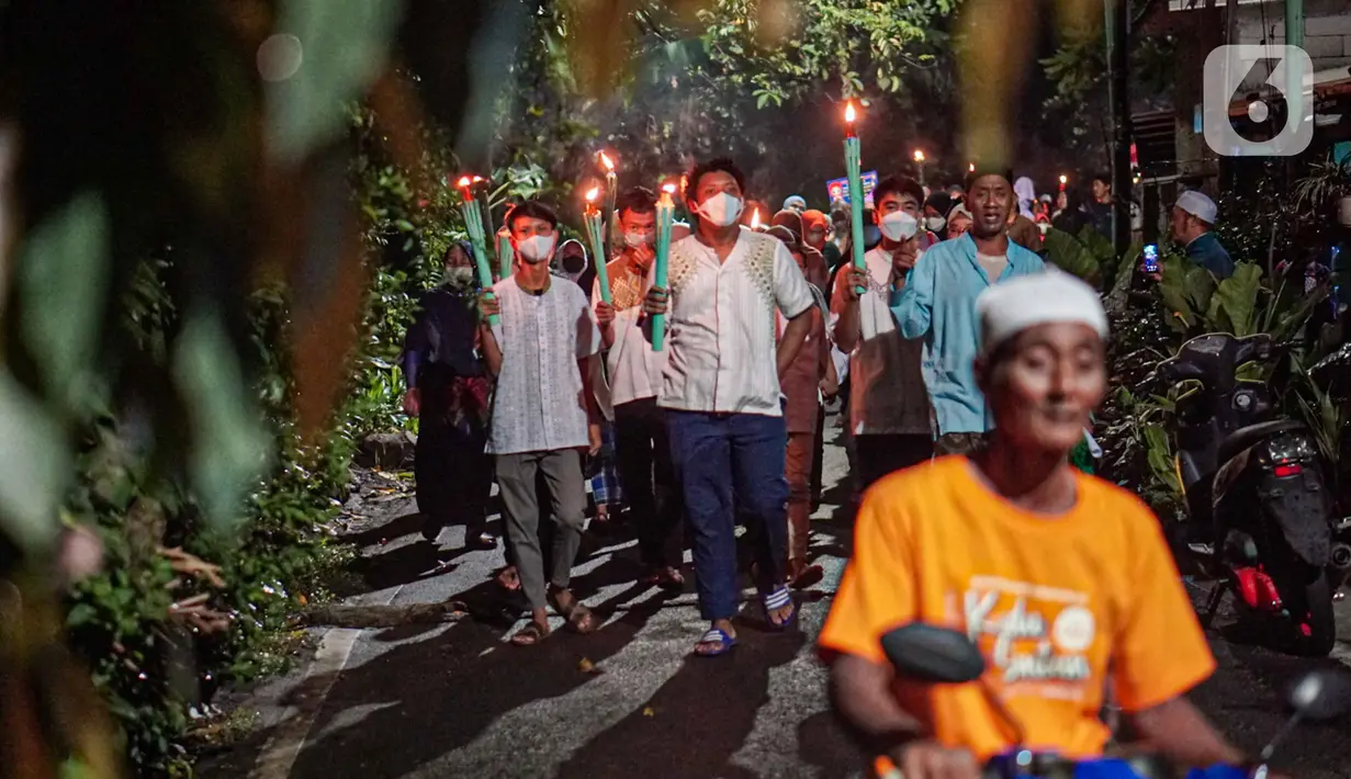 Warga mengikuti pawai obor menyambut Ramadan di kawasan Matraman Dalam, Jakarta, Minggu (27/3/2022). Pawai obor tersebut juga digelar untuk meningkatkan silaturahmi dan ukhuwah sesama umat Muslim serta menyemarakkan syiar Islam di Ibu Kota. (Liputan6.com/Faizal Fanani)