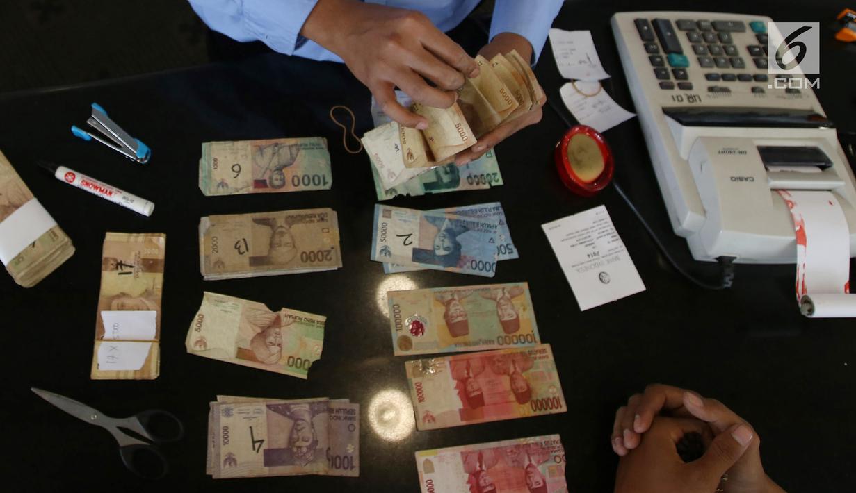 Karyawan memeriksa uang kertas rupiah yang rusak di tempat penukaran uang rusak di Gedung Bank Indonessia, Jakarta (4/4). Bank Indonesia memfasilitasi masyarakat untuk menukarkan uang rupiah yang rusak secara gratis. (Merdeka.com/Arie Basuki)