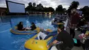 Penonton bersiap-siap untuk menonton pemutaran film buatan sutradara Steven Spielberg "Jaws" dengan ban karet di kolama renang di Brockwell Lido, London, Inggris, Kamis (17/9/2015). (REUTERS/Luke MacGregor)