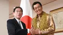 Komedian Jepang Pikotaro berjabat tangan dengan Menteri Luar Negeri Jepang Fumio Kishida di Kementerian, Tokyo, Rabu (12/7). Pikotaro diundang untuk mendampingi Menlu ke pertemuan PBB di markas besar, New York. (AP/ Eugene Hoshiko)