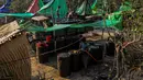 Pekerja mengisi sejumlah drum dengan minyak mentah saat melakukan pengeboran di sumur minyak ilegal di Minhla, Myanmar, 10 Maret 2019. Para pekerja dapat memperoleh hingga 600 barel minyak per hari. (Ye Aung THU/AFP)