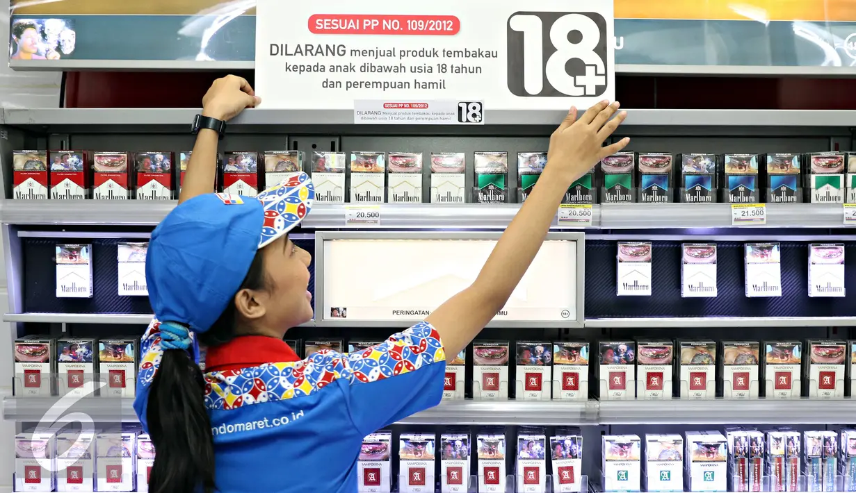 Petugas menempelkan papan peraturan penjualan rokok di gerai Indomaret, Jakarta, Selasa (3/11). Program untuk meningkatkan kesadaran masyarakat akan pelarangan pembelian produk tembakau oleh anak di bawah 18 tahun. (Liputan6.com/Immanuel Antonius)