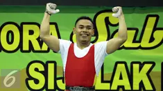 Lifter Jawa Timur, Eko Yuli Irawan mengangkat tangan usai memastikan emas di kelas 62kg putra PON XIX Jabar di Gymnasium Stadion Si Jalak Harupat, Kab Bandung, Selasa (20/9/2016). Total angkatan Eko Yuli mencapai 307kg. (Liputan6.com/Helmi Fithriansyah)