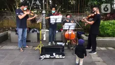 Musisi lokal Bogor memainkan musik klasik di pedestrian Kebun Raya, Jalan Pajajaran, Bogor, Jawa Barat, Minggu (14/6/2020). Untuk memenuhi kebutuhan hidup akibat sepinya job pertunjukan selama pandemi COVID-19, mereka memilih mengamen saat warga berolahraga. (merdeka.com/Arie Basuki)