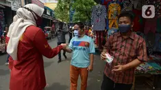 Petugas membagikan masker kepada warga di Pasar Jatinegara, Kamis (10/9/2020). Petugas gabungan terus melakukan himbauan untuk memakai masker dan membagikan masker di pasar tersebut. (merdeka.com/Imam Buhori)