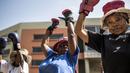 Para nenek pemanasan sebelum latihan tinju pada Boxing Gogos di Cosmo City, Johannesburg, Selasa (19/9/2017). Berkat latihan rutin yang dipimpin Claude Maphosa ini para lansia berhasil sembuh dari penyakit dan hidup lebih sehat. (AFP/Gulshan Khan) 