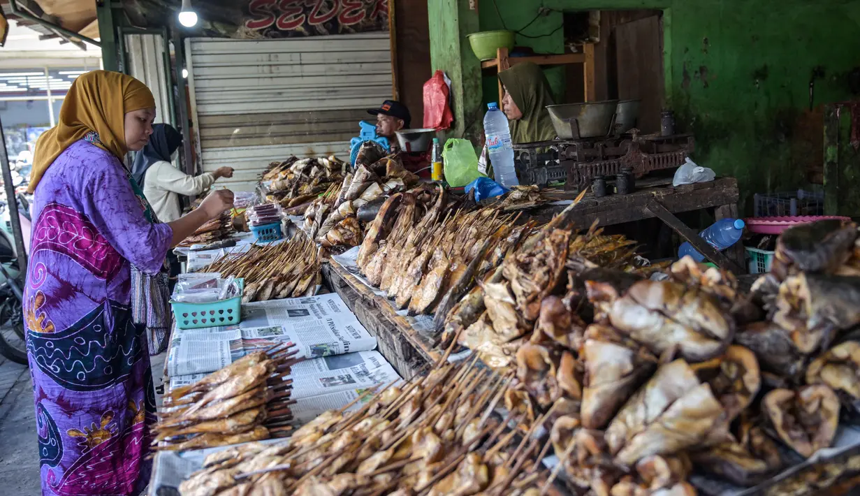 Realisasi itu setara 72,9 persen dari total realisasi penyaluran yang telah mencapai Rp 96 triliun. Adapun target penyaluran KUR UMKM tahun ini naik menjadi Rp 320 triliun. Tampak dalam foto, seorang wanita membeli ikan asap di Surabaya, Jawa Timur, Rabu 6 Mei 2026. (JUNI KRISWANTO/AFP)