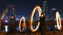 Peserta membuat lingkaran api jelang perayaan "Jeongwol Daeboreum" (Bulan Purnama) di Seoul, Korea Selatan (1/3). Permainan ini dipercaya dapat menyuburkan tanah dan menyingkirkannya hama sehingga memastikan hasil panen melimpah. (AFP Photo/Jung Yeon-je)
