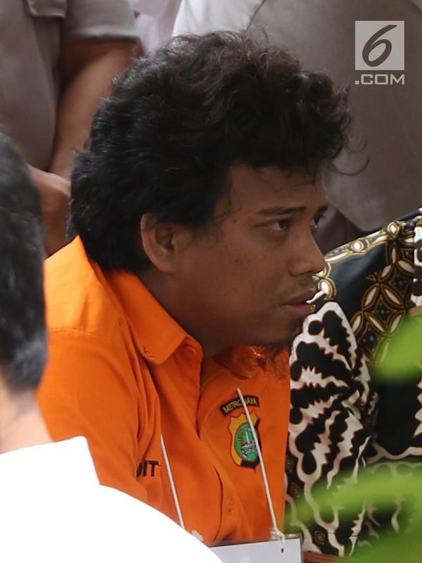 Tersangka IAW menjalani proses rekonstruksi Lapangan Tembak Senayan, Jakarta, Jumat (19/10). IAW menjalani 25 adegan rekonstruksi terkait dugaan enam peluru yang tertembak ke enam ruangan di Gedung DPR RI. (Liputan6.com/Immanuel Antonius)