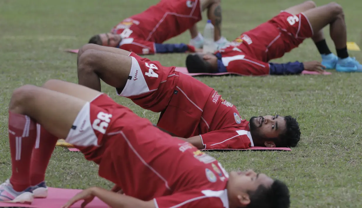 Pemain Arema Cronus, Ferry Aman Saragih merenggangkan otot saat latihan jelang leg kedua semi final Piala Presiden melawan Sriwijaya F.C di Stadion Gajayana, Malang, Rabu (7/10/2015). (Bola.com/Vitalis Yogi Trisna)