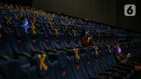 Penonton duduk dengan menjaga jarak di dalam bisokop CGV Grand Indonesia, Jakarta, Kamis (16/9/2021). Pemerintah memberikan kelonggaran dengan memperbolehkan bioskop buka kembali di wilayah berstatus pemberlakuan pembatasan kegiatan masyarakat (PPKM) level 3 dan 2. (Liputan6.com/Faizal Fanani)