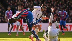 Bek Manchester United, Noussair Mazraoui, terjatuh saat berebut bola dengan striker Crystal Palace, Jean-Philippe Mateta, dalam laga pekan 13 Premier League 2025/2026 d Selhurst Park, Minggu (30/11/2025). (Glyn KIRK / AFP)