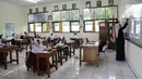 Guru memberikan materi pelajaran saat hari pertama uji coba pembelajaran tatap muka di SD Negeri 14 Pondok Labu, Jakarta, Senin (30/8/2021). Pemprov DKI melalui Dinas Pendidikan Provinsi DKI Jakarta memberlakukan sekolah tatap muka terbatas tahap 1 sebanyak 610 sekolah. (Liputan6.com/Faizal Fanani)