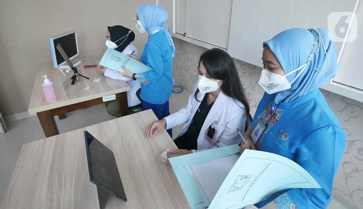 Dokter Spesialis Onkologi Radiasi, Ade Margaretha (kedua kanan) bersama Dokter Umum Indria Febriani (kiri) saat memberikan pelayanan medis jarak jauh atau Telemedicine pada pasien umum di Rumah Sakit Umum Daerah (RSUD) Pasar Minggu, Jakarta, Jumat (18/2/2022). (Liputan6.com/Herman Zakharia)