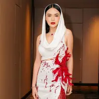 Tampilan terbaru Amanda Manopo mengenakan hooded dress warna putih dengan aksen fringe dan bulu-bulu merah dari desainer Yenty Tan. [@bellyiverzon]