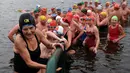 Sejumlah perenang naik meninggalkan danau usai mengikuti lomba berenang di Danau Serpentine di Hyde Park, London, Inggris, Minggu (25/12). Lomba ini digelar untuk merayakan Natal 2016. (REUTERS/Toby Melville)